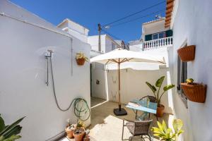 un patio con sombrilla y mesa en Casa Ana Mar, en Vila do Bispo
