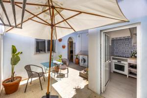 Una gran sombrilla en una cocina con una mesa y sillas. en Casa Ana Mar, en Vila do Bispo