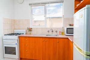 a kitchen with a stove and a sink and a window at Apartment 22 Burswood in Perth