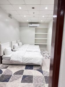 two beds in a room with a checkered floor at شقق نرمادا المفروشه402 in Medina