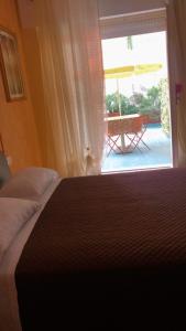 a bedroom with a bed and a window with a patio at Affittacamere Selene in Sanremo