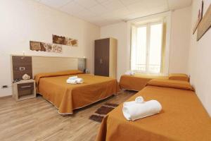 - une chambre avec 3 lits et des serviettes dans l'établissement Albergo Maccotta, à Trapani