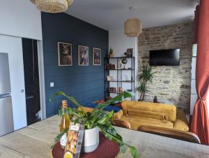 a living room with a couch and a table at la Pléiade in Pont-Hébert