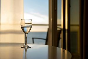 un verre de vin assis au-dessus d'une table dans l'établissement ONYM Curated Villas, à Plaka