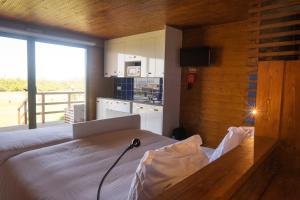 a bedroom with a bed with a view of a kitchen at PenichePraia - Bungalows, Campers & SPA in Peniche