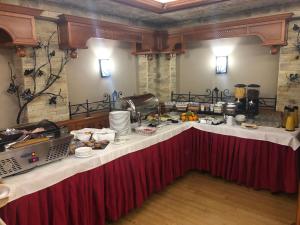 a buffet with a long table in a room with food at Villa Hotel in Debrecen