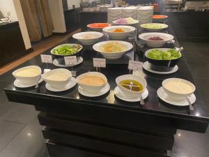 ein Buffet mit Schalen Essen auf dem Tisch in der Unterkunft Sunee Grand Hotel and Convention Center in Ubon Ratchathani