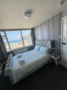 a bedroom with a bed with a large window at Shore Lodge in Newquay