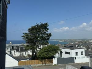 a view of a city with a tree and the ocean at Shore Lodge in Newquay