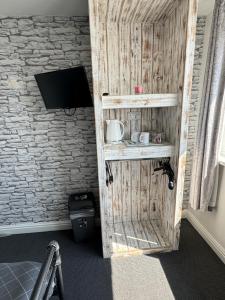 a room with a wooden door with a tv on a wall at Shore Lodge in Newquay