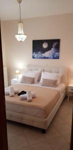 een groot bed in een slaapkamer met een kroonluchter bij ATHINAS APARTMENT in Limenas