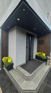 a building with two potted plants and a door at Zebrzydowicka 37 in Rybnik