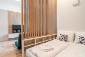 En eller flere senge i et værelse på Patronka Apartments - Stylish apartment with a divided sleeping area