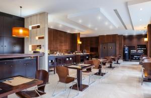 a restaurant with tables and chairs and a bar at Hotel SB Express Madrid Norte in San Sebastián de los Reyes