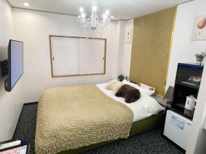 a dog laying on a bed in a bedroom at Restay lagoon in Tokyo