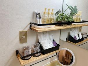 a shelf on a wall with bottles and a mirror at Restay lagoon in Tokyo
