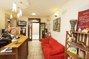 a living room with a red couch and a table at Albergo Maccotta in Trapani