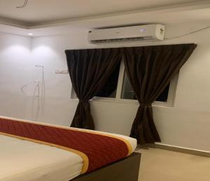 een slaapkamer met een bed en een raam bij G R B Hotels Aishwarya Grand in Pondicherry