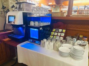 ein Tisch mit weißen Tellern und Gläsern in der Unterkunft Villa Hotel in Debrecen + 65 Fotos