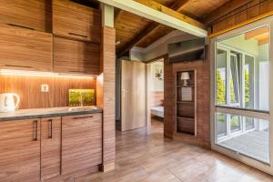 cocina con paneles de madera y ventana grande en Ośrodek Wczasowy Boski Raj, en Sianożęty