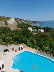 a swimming pool with a view of the ocean at Queen's Garden Balchik apartment in Balchik