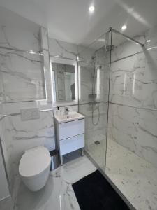 uma casa de banho branca com um WC e um chuveiro em T2 Neuf Hyper centre ville Sanary em Sanary-sur-Mer