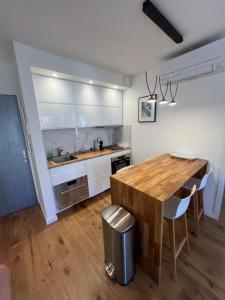 uma cozinha com uma mesa de madeira e armários brancos em T2 Neuf Hyper centre ville Sanary em Sanary-sur-Mer