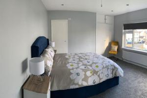 a bedroom with a bed and a table with a lamp at Tranquil Algeo Drive in Enniskillen