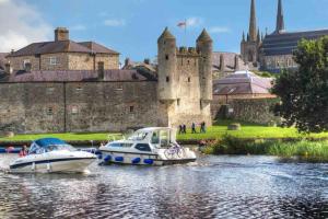 two boats in the water in front of a castle at Tranquil Algeo Drive in Enniskillen