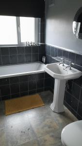 a bathroom with a sink and a tub and a toilet at Paul's Place in Longbridge