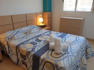 Un dormitorio con una cama con toallas. en Holidaytorremar-72-MED022, en El Borseral
