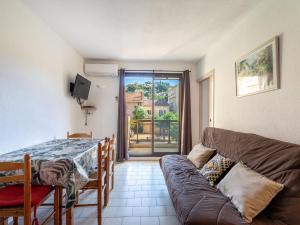 una sala de estar con un sofá y una mesa en Apartment Saint James-3 by Interhome, en Le Lavandou