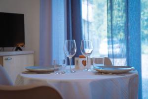 a table with two wine glasses and plates on it at Vista sul Castello in Vigolzone