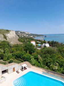 a swimming pool with a view of the ocean at Queen's Palace Balchik apartment in Balchik