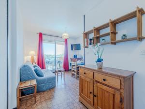 a living room with a blue couch and a table at Apartment Les Barcarelles by Interhome in Le Barcarès
