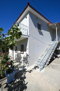 a white house with a staircase on the side at Anchor Villa in Skiathos Town