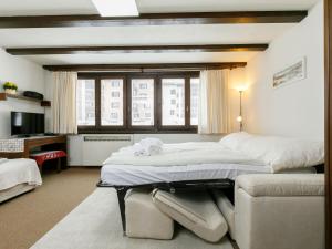 a bedroom with a large bed and a couch at Apartment Residenza Chesa Margun 35-1 by Interhome in Surlej