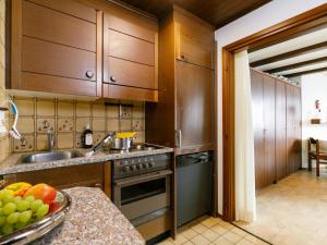 a kitchen with wooden cabinets and a sink at Apartment Residenza Chesa Margun 34-7 by Interhome in Surlej