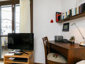 a room with a desk with a television and a chair at Apartment Residenza Chesa Margun 34-7 by Interhome in Surlej