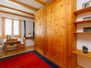 a room with wooden walls and a table and a red rug at Studio Residenza Chesa Margun 34-4 by Interhome in Surlej +19 photos