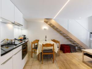 een keuken en eetkamer met een tafel en een trap bij Apartment Residenza Chesa Margun 36-3 by Interhome in Surlej