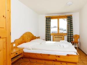 um quarto com uma cama de madeira e uma janela em Apartment Residenza Chesa Margun 57-1 by Interhome em Surlej