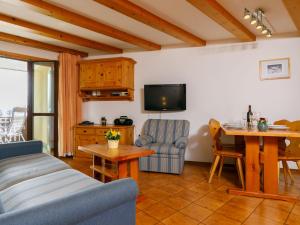 a living room with a couch and a table and a tv at Apartment Residenza Chesa Margun 57-1 by Interhome in Surlej +25 photos