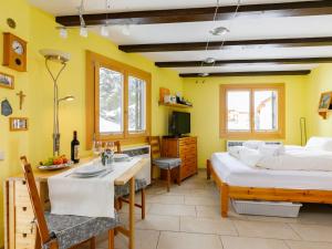 a bedroom with two beds and a table and a kitchen at Apartment Residenza Chesa Margun 34-6 by Interhome in Surlej