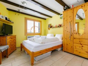 a bedroom with a large bed and a tv at Apartment Residenza Chesa Margun 34-6 by Interhome in Surlej +19 photos