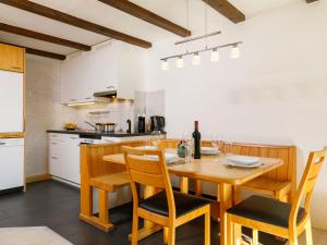 a kitchen with a wooden dining room table and chairs at Apartment Residenza Chesa Margun 58-5 by Interhome in Surlej +24 photos
