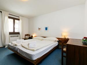Un dormitorio con una cama grande y una mesa. en Apartment Residenza Chesa Margun 23-1 by Interhome, en Surlej