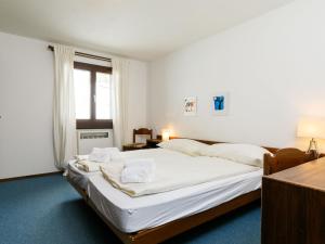 Un dormitorio con una cama grande con sábanas blancas. en Apartment Residenza Chesa Margun 23-1 by Interhome, en Surlej 17 fotos más