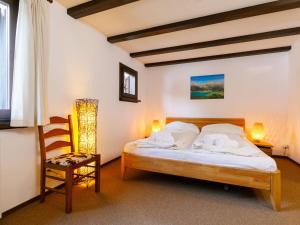 a bedroom with a bed and a chair at Apartment Residenza Chesa Margun 13-2 by Interhome in Surlej