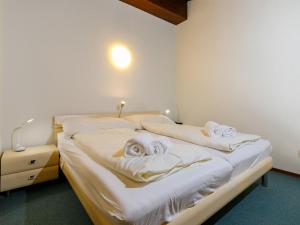 ズルレイにあるApartment Residenza Chesa Margun 47-2 by Interhomeのマスクが置かれた整えられていないベッドが2つある寝室